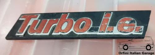 7577432  Front Grill Badge Scritta Fiat Uno Croma Uno Turbo IE